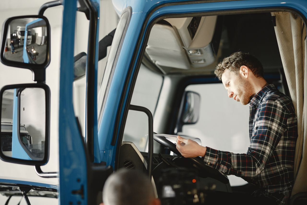 Man in a truck cab looking at a tablet